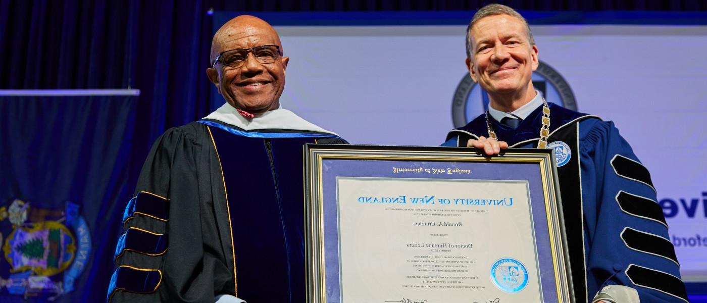 UNE President James Herbert holds an honorary degree awarded to Ronald A. Crutcher
